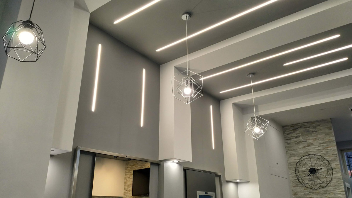 tre lampadari appesi al soffitto e luci lungo le pareti