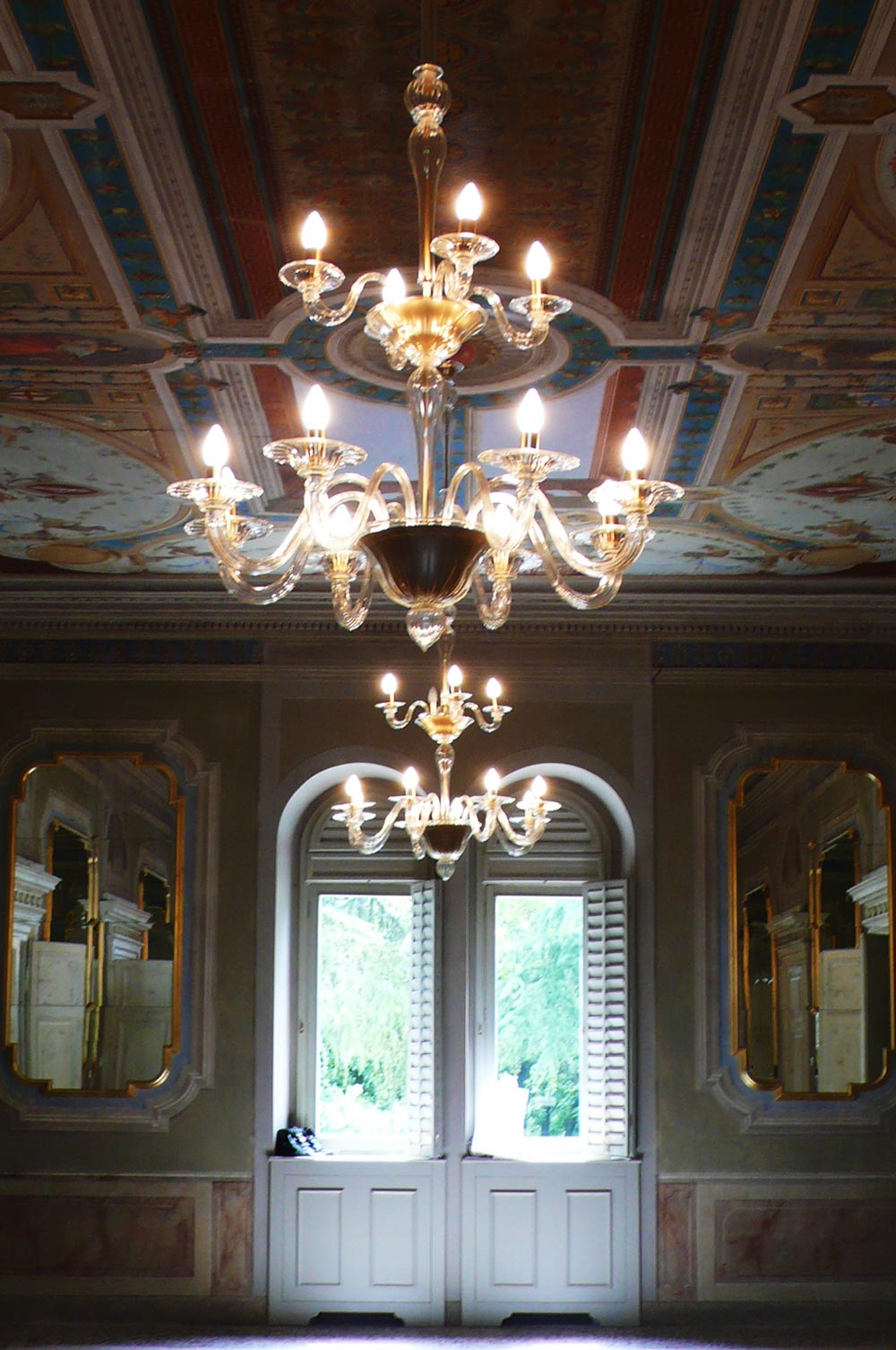 Due candelabri in fila appesi al soffitto all'interno di una stanza di una villa