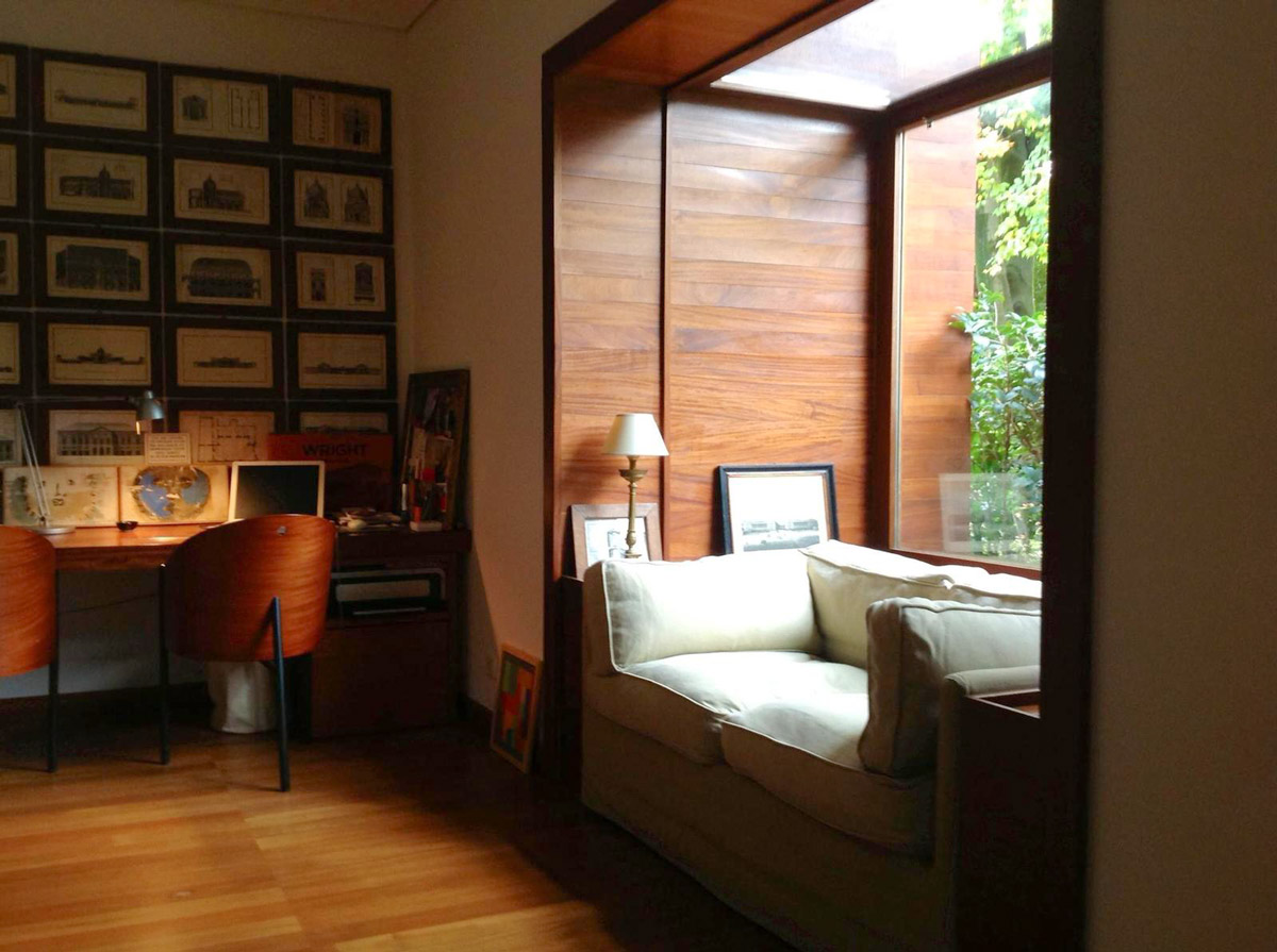 Interior of a wooden room with a wall decorated with paintings