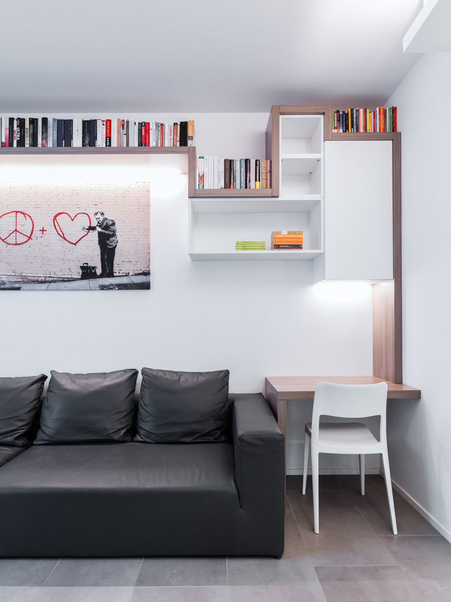 Study corner consisting of a black leather sofa and alongside a small wooden desk