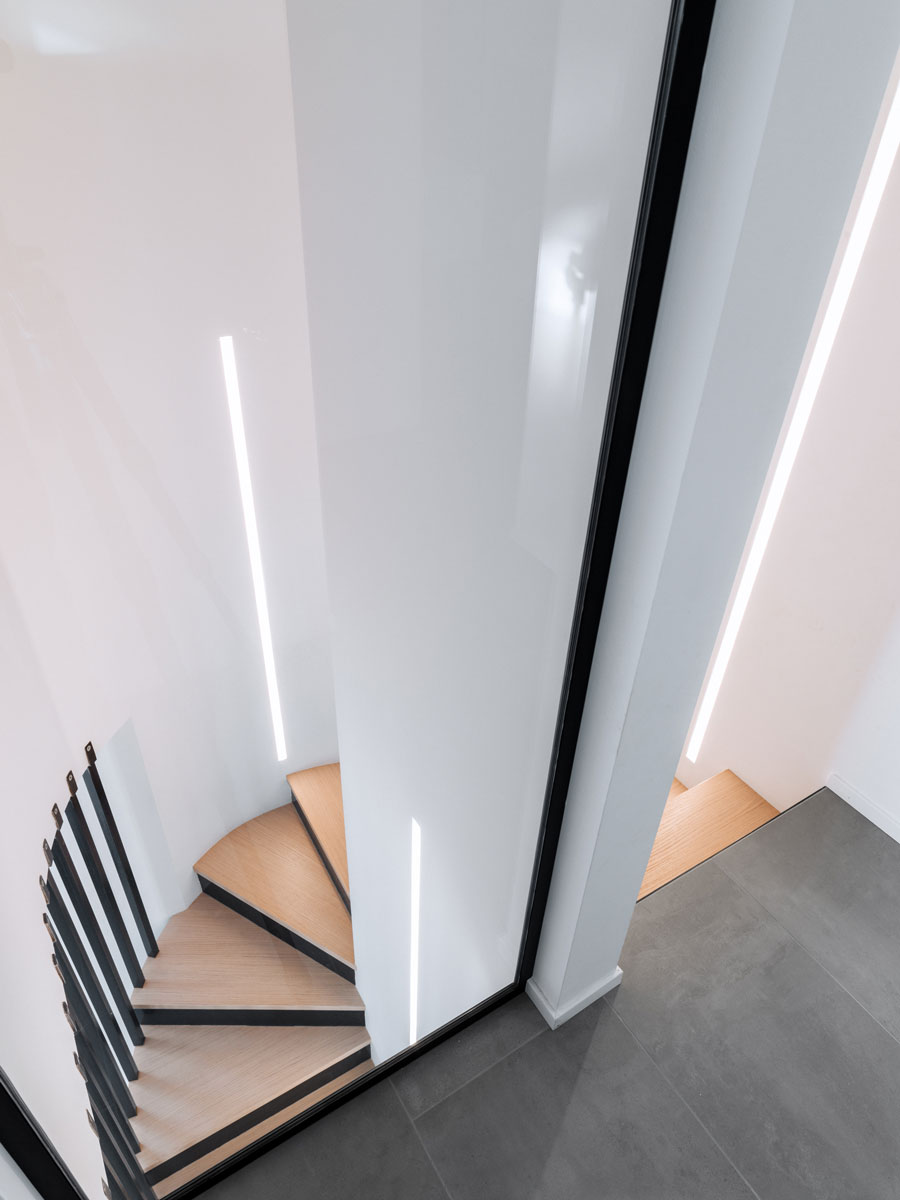 Column with a spiral staircase that descends into the living area