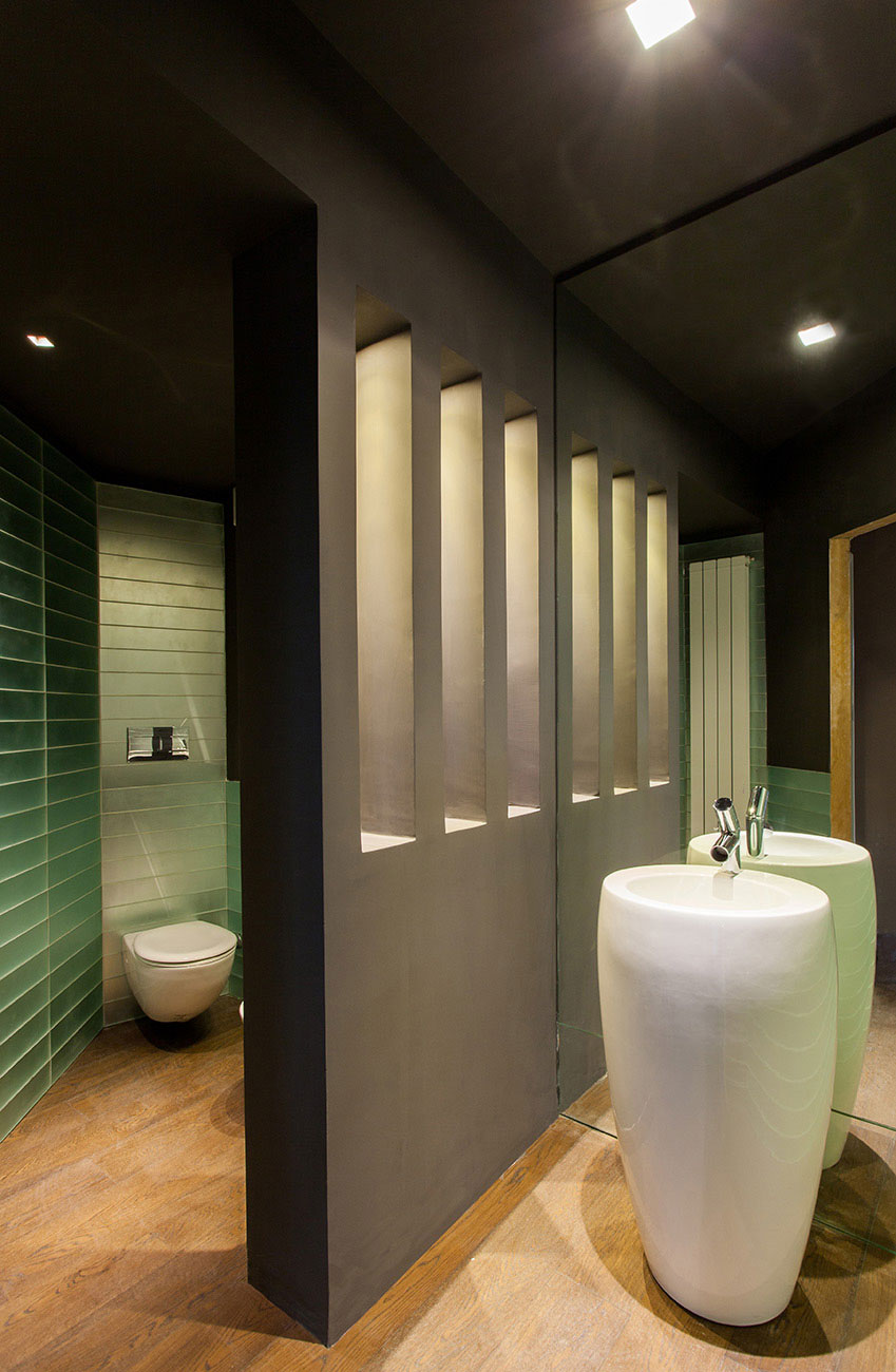 Bathroom with a black wall that divides the sanitary ware from the sink