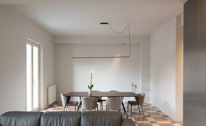Foto del salotto con un divano e un tavolo con sopra orchidee