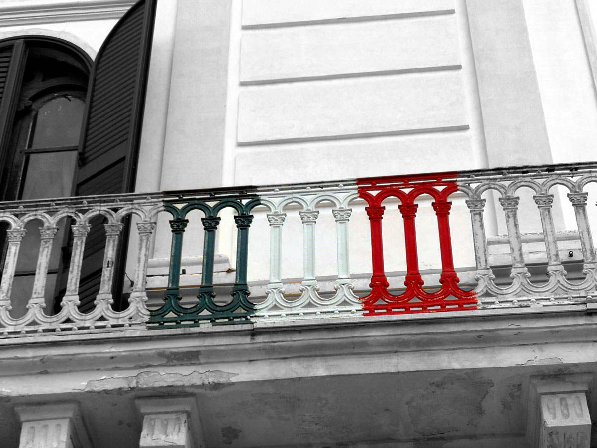Foto di un balcone con dipinta la bandiera italiana sulla ringhiera
