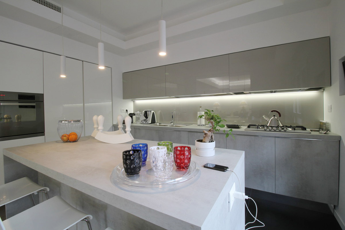 White kitchen island with glasses and a bonsai resting on it