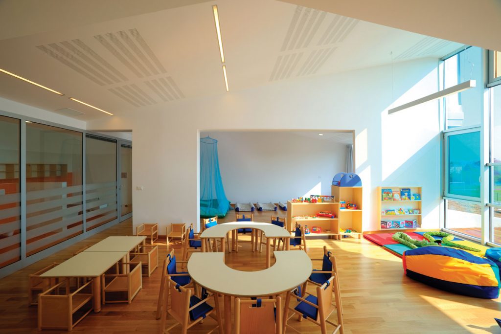 Classroom with benches and chests of drawers full of toys