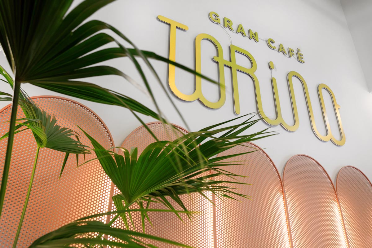 Gold-colored logo of the Gran Cafe Torino fixed on the wall of the venue