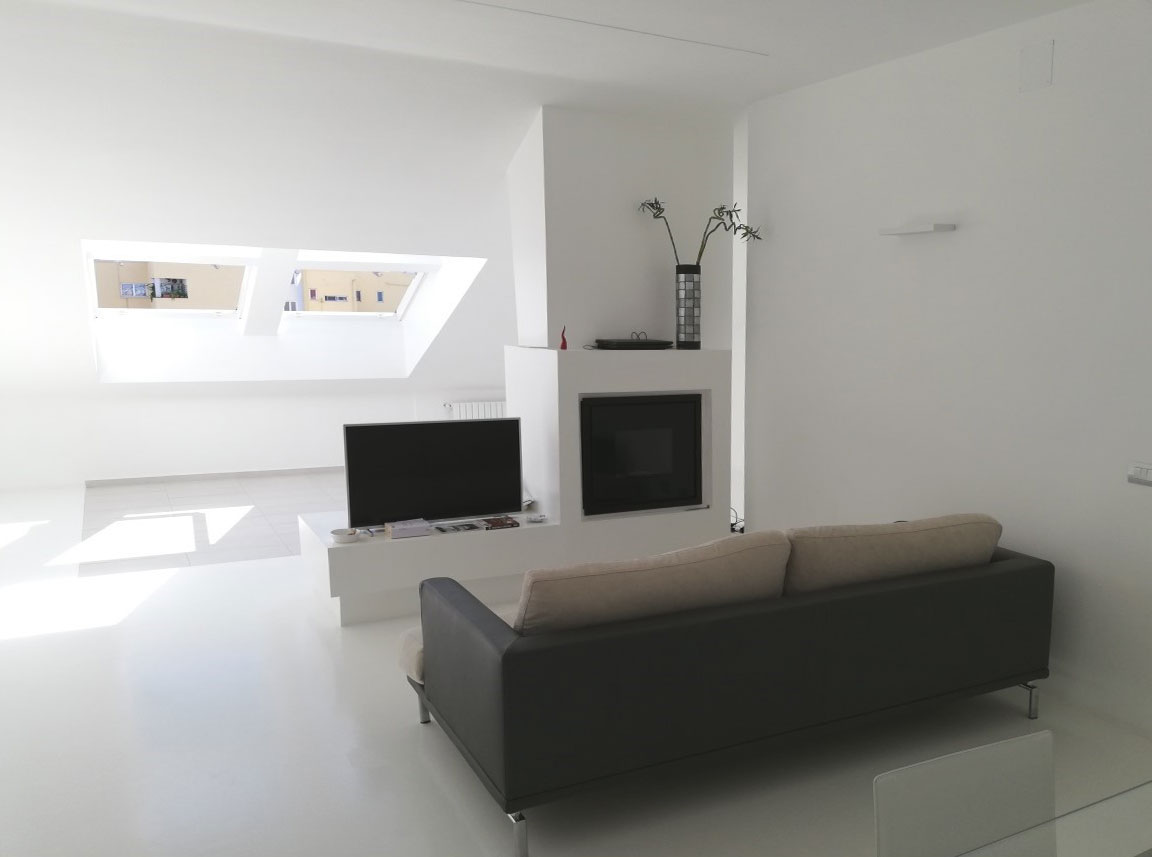 Living room with fireplace, television and a black leather sofa in front