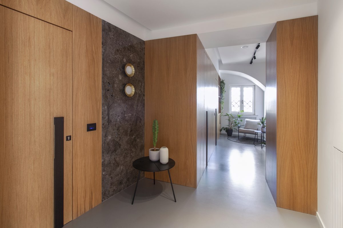 Corridor with wooden cabinets along the walls and a window at the bottom