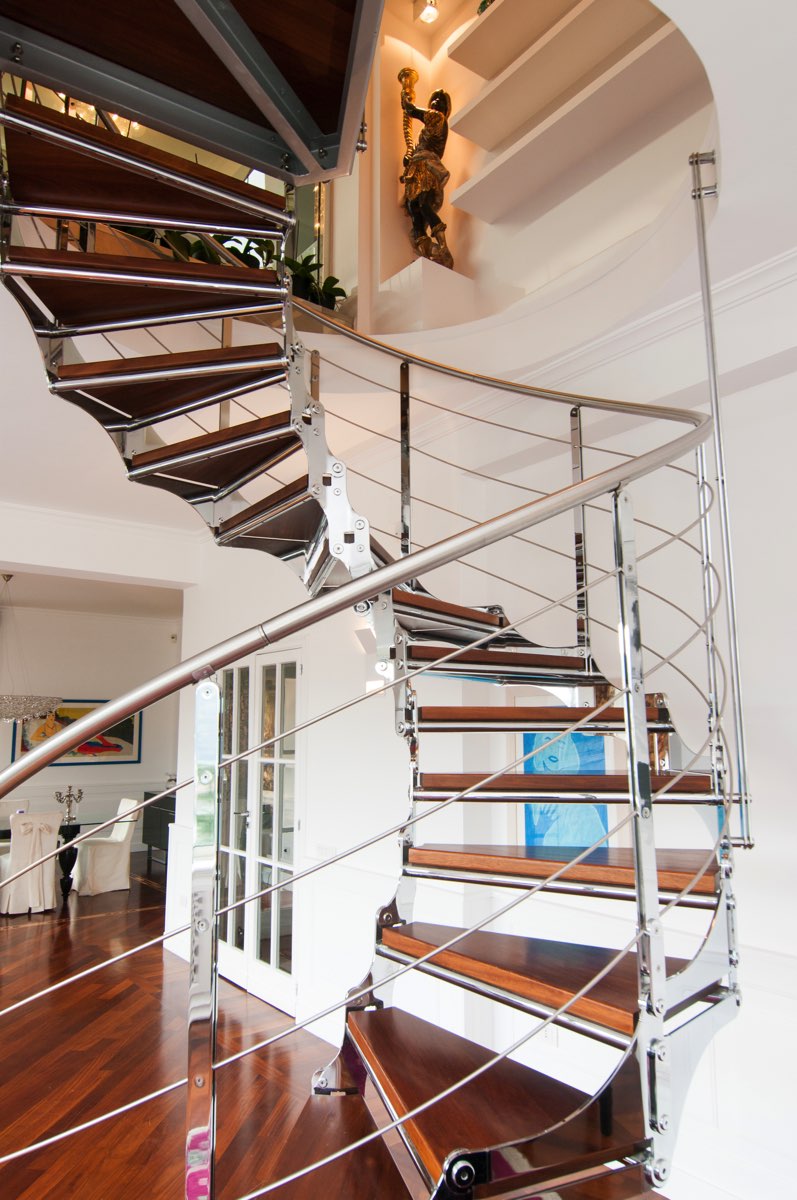 the vertical path between polished steel and solid wood tread reaches the next floor