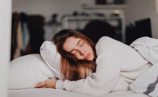 Ragazza che dorme su un letto bianco