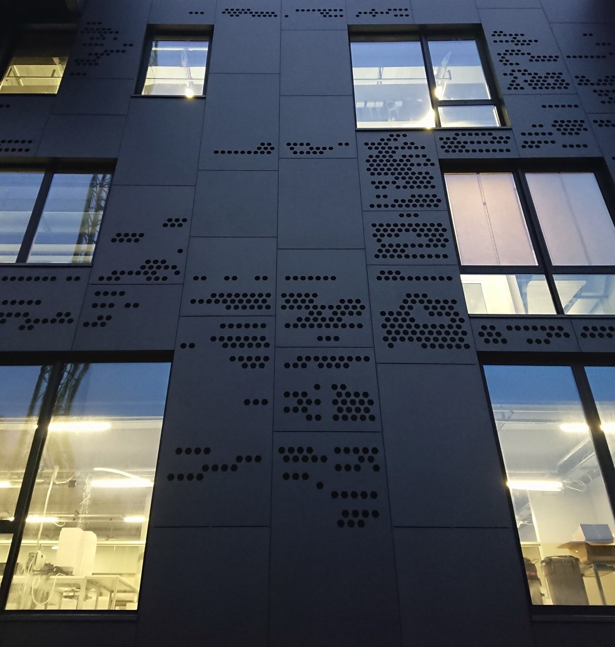 Wall of a black building with some closed windows