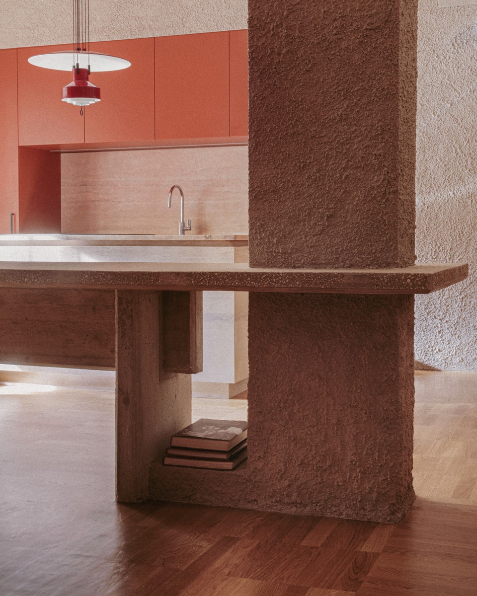 Fixed concrete dining table as a focal point in the Four Spaces apartment.