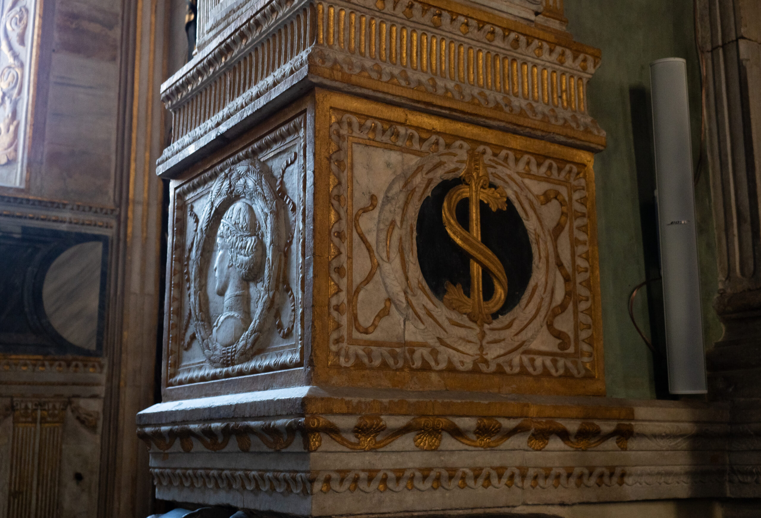 Particolare in marmo scolpito con simbologia religiosa in un interno di un'antica chiesa.
