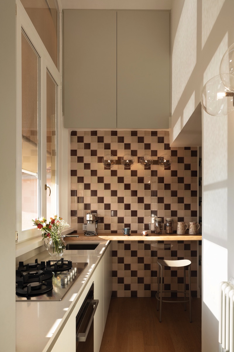 Cucina con bancone e muro piastrellato
